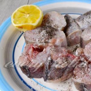당근과 양파를 곁들인 생선 프라이팬에 양파와 당근을 곁들인 생선